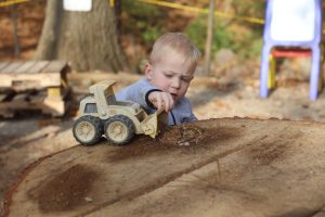 While in the school’s outdoor classroom, a John Cary Early Childhood Center student plays with a truck on a tree stump, scooping and dumping woodchips. The tree, now a stump, was recently cut down due to dangerous limbs. “Now it’s another toy,” Gerry Spitznagel, Mehlville School District’s head groundskeeper, said.
