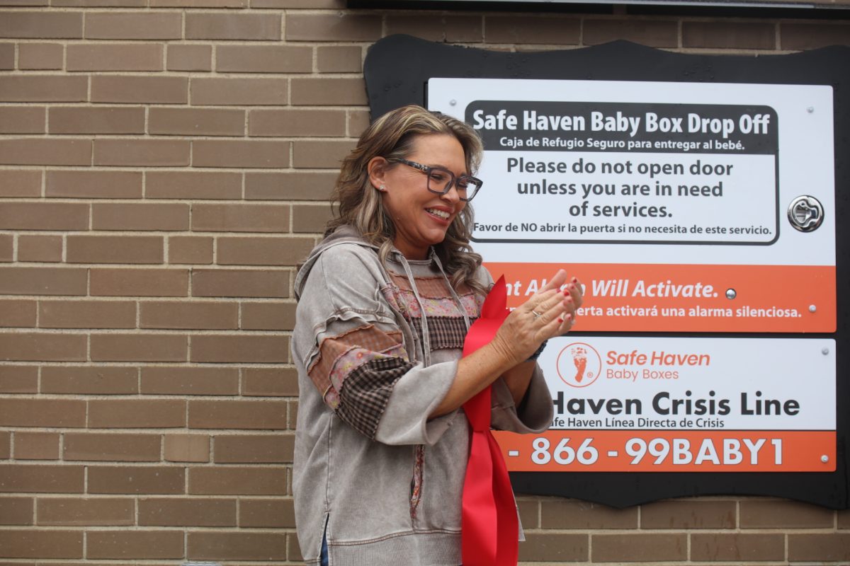 Monica Kelsey, founder and CEO of Safe Haven Baby Box, claps after the ribbon is cut on the box at Mehlville Fire House 5.