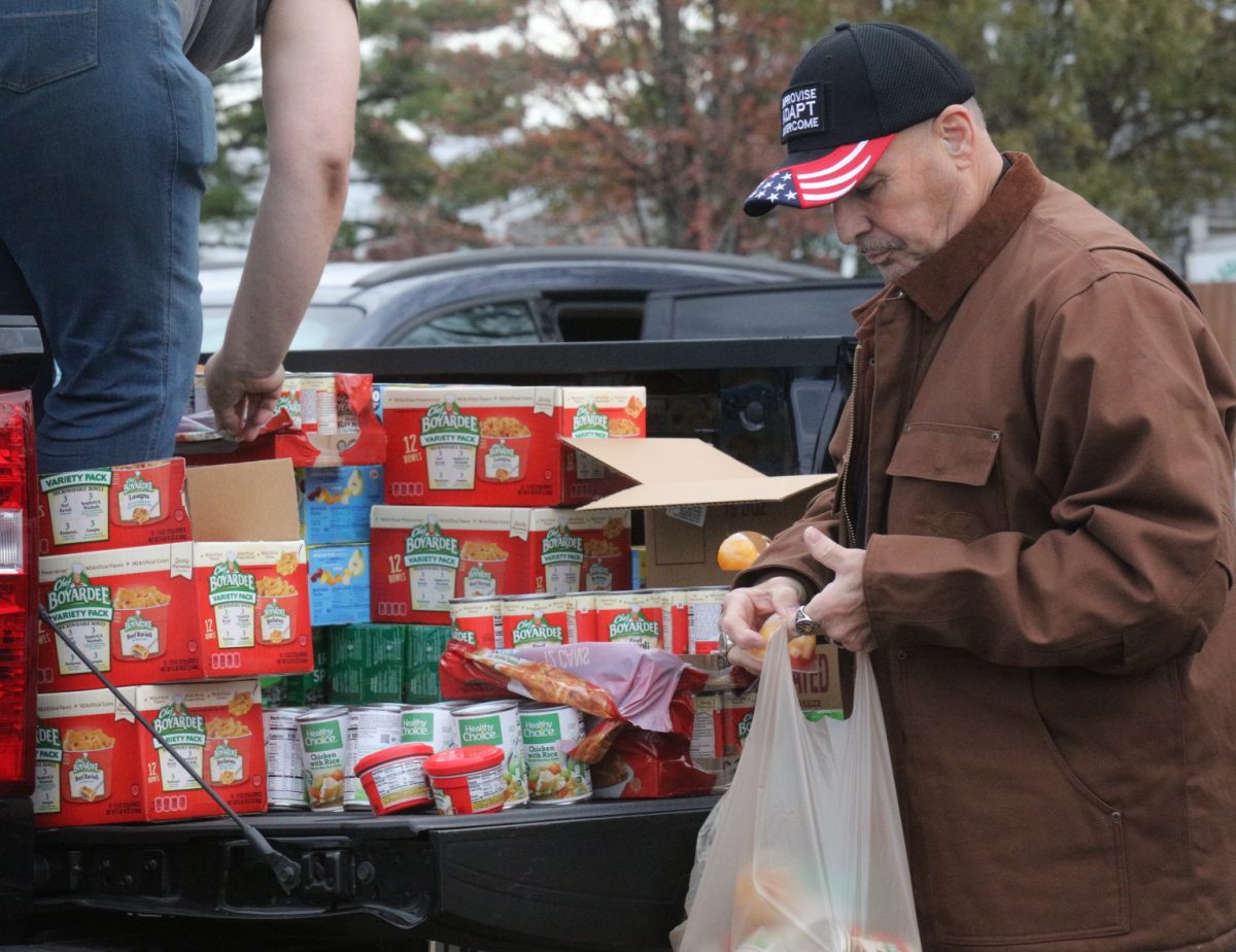 Volunteers sort food into bags to be loaded into attendees' cars.