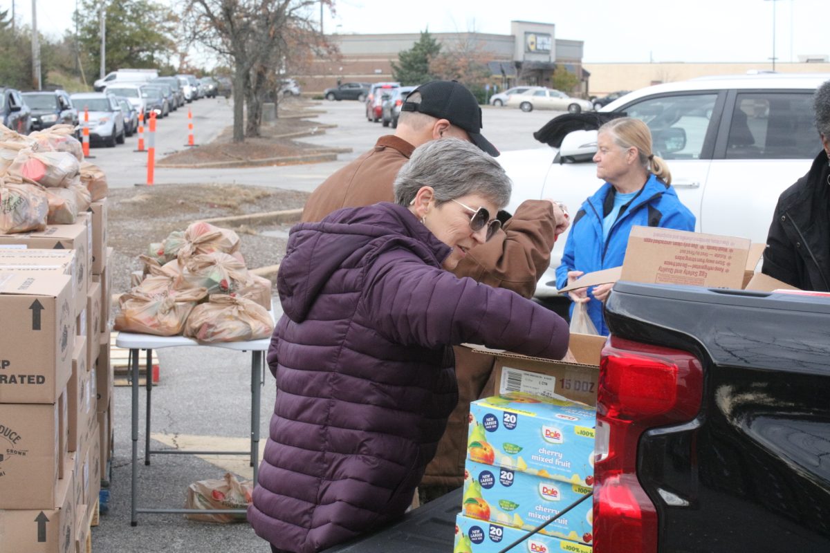 Volunteers unload food from the back of a truck so it can be distributed.