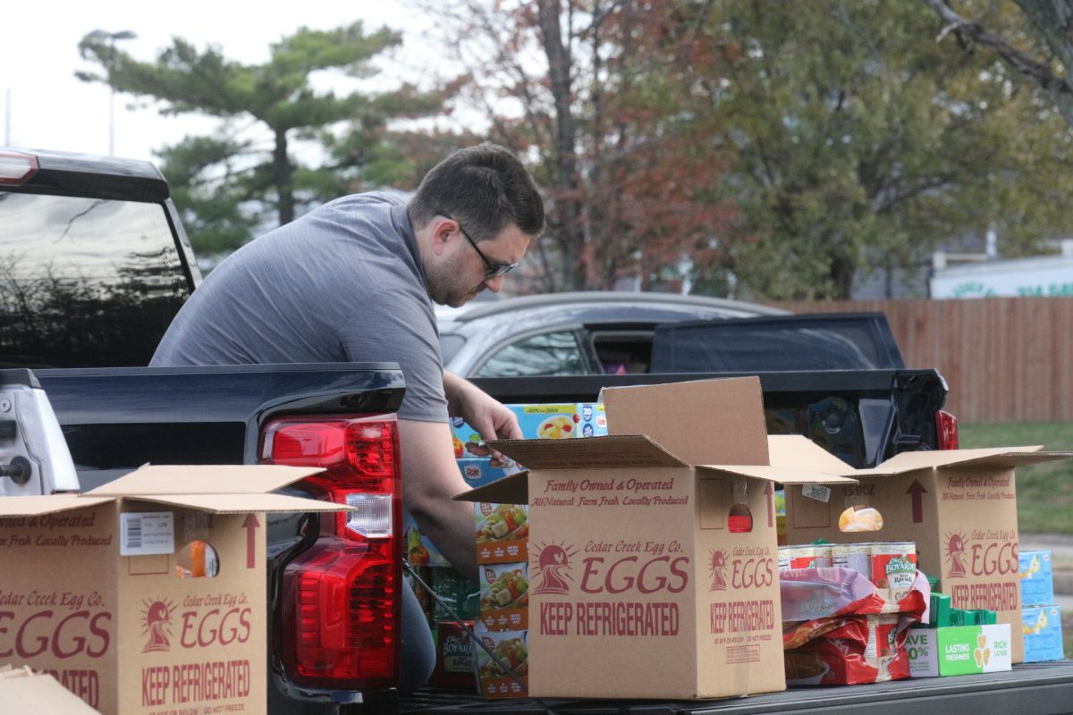 A volunteer unboxes food so it can be distributed to those in need.