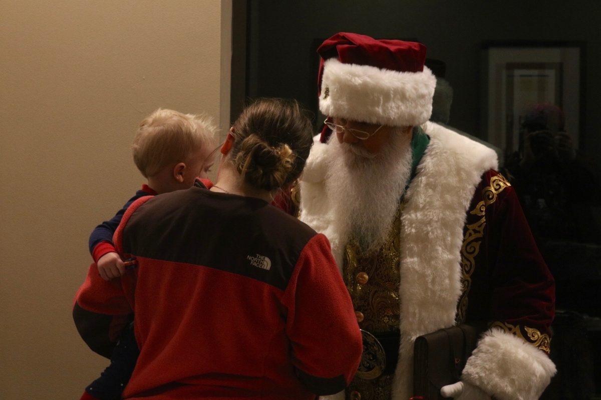 Santa talks to a young child in attendance.