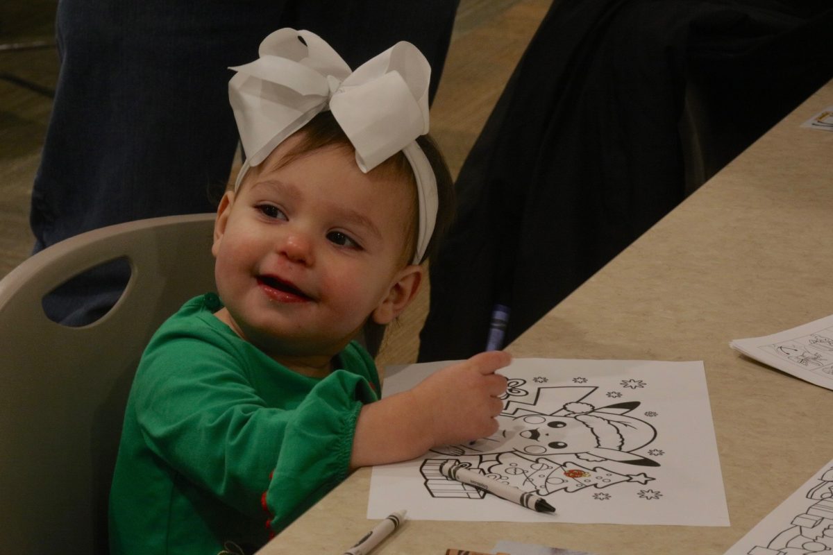 With a smile, a child draws on a festive Pikachu coloring sheet.