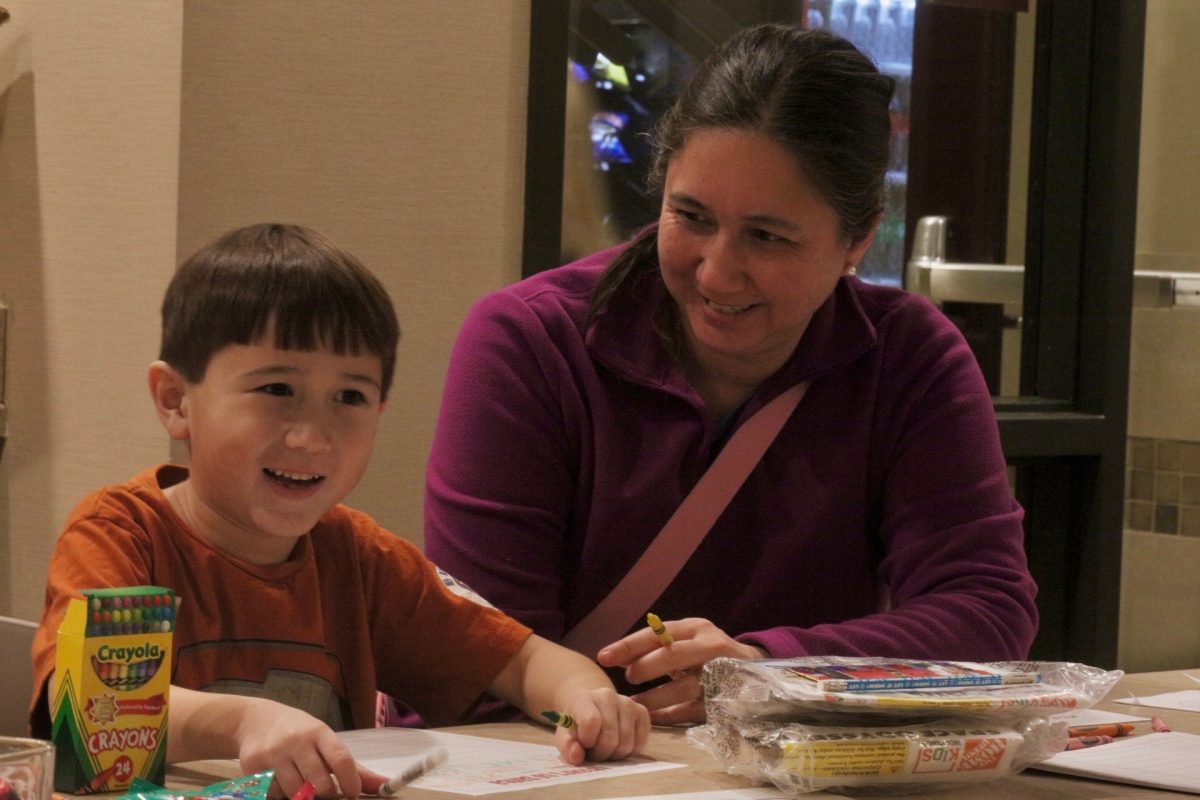 A mother and her son color together.