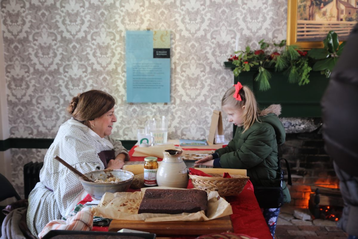 Suzanne Corbett demonstrates 19th-century baking methods to a curious young onlooker in the historic stone kitchen at White Haven, President Ulysses S. Grant’s home, on Dec. 6.