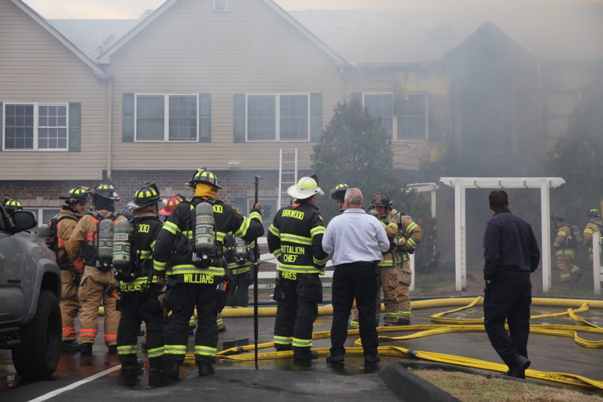 Firefighters and onlookers crowded in the parking lot of the Arthur Commons condominiums. 