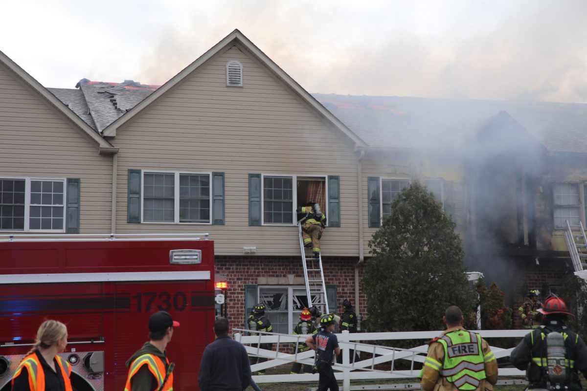 A firefighter breaks and climbs into a second-story window of the condominiums.