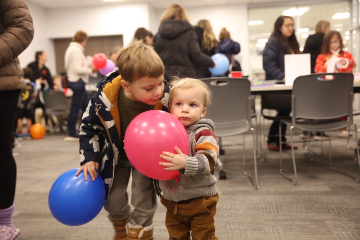 One young attendee holds tightly onto his balloon from the drop.