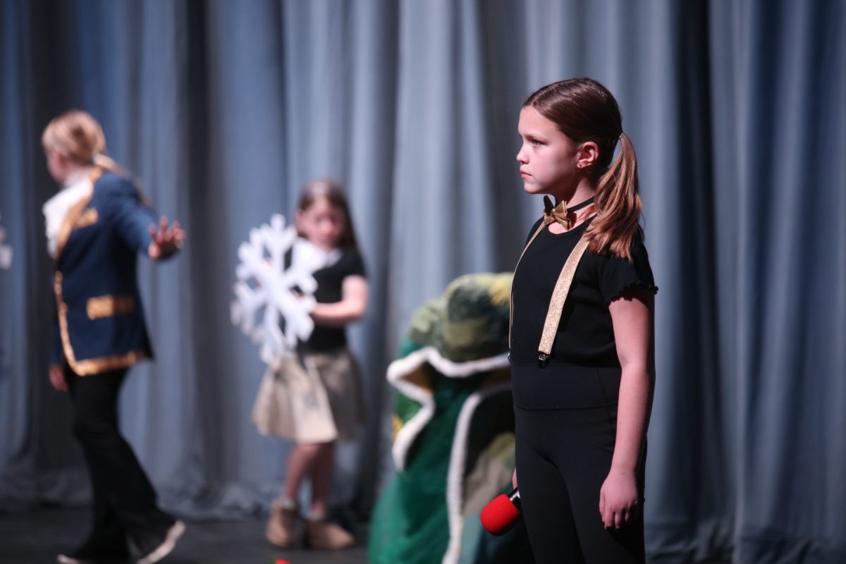 One of the narrators in Lindbergh Schools' production of "Beauty and the Beast Jr." looks out into the crowd, awaiting her turn to speak.