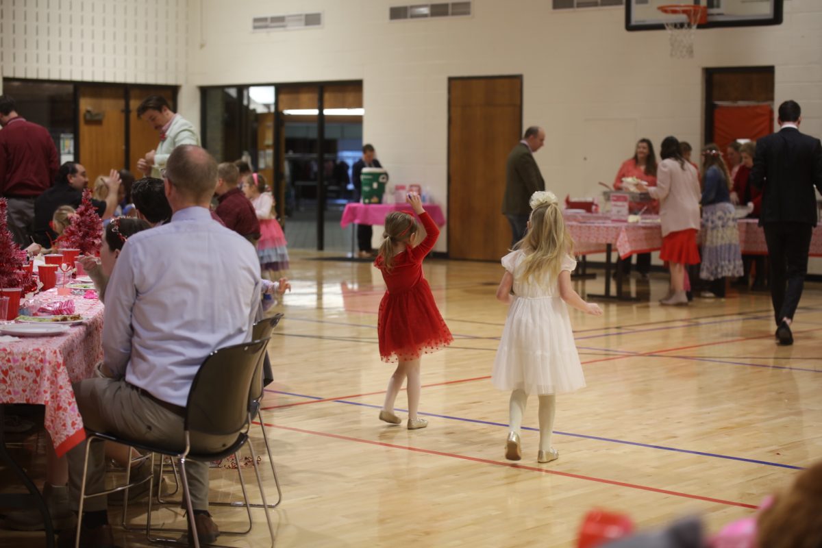 Two girls play with a bouncy ball in the gym of the Crestwood Community Center, 9245 Whitecliff Park Lane, where the Sweetheart Dance took place.