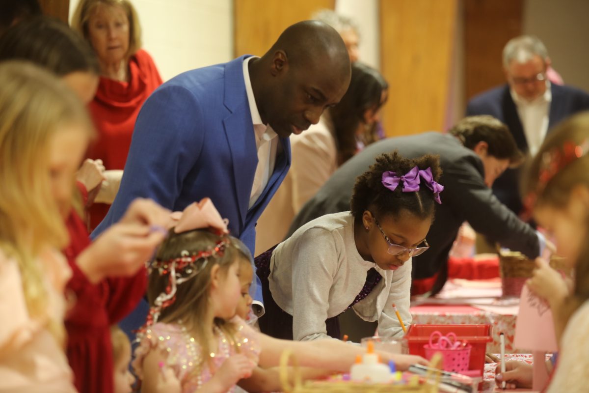A father watches his daughters make Valentine's cards at the craft table at Crestwood's annual Sweetheart Dance on Feb. 7. 