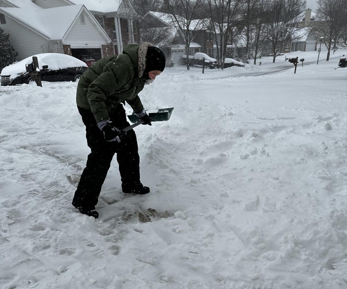 Kolby Craden shovels snow.