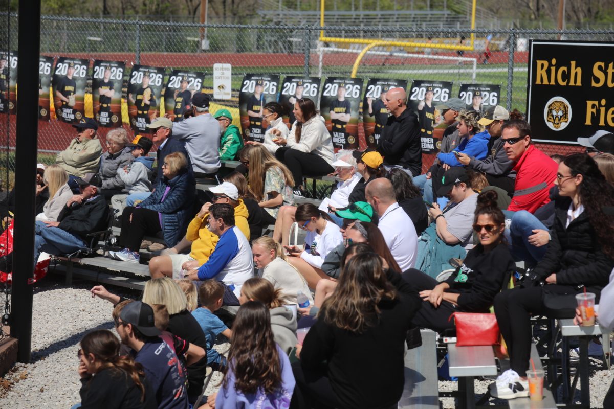 Attendees of the OHS versus MHS baseball game sit on the bleachers to watch the game.