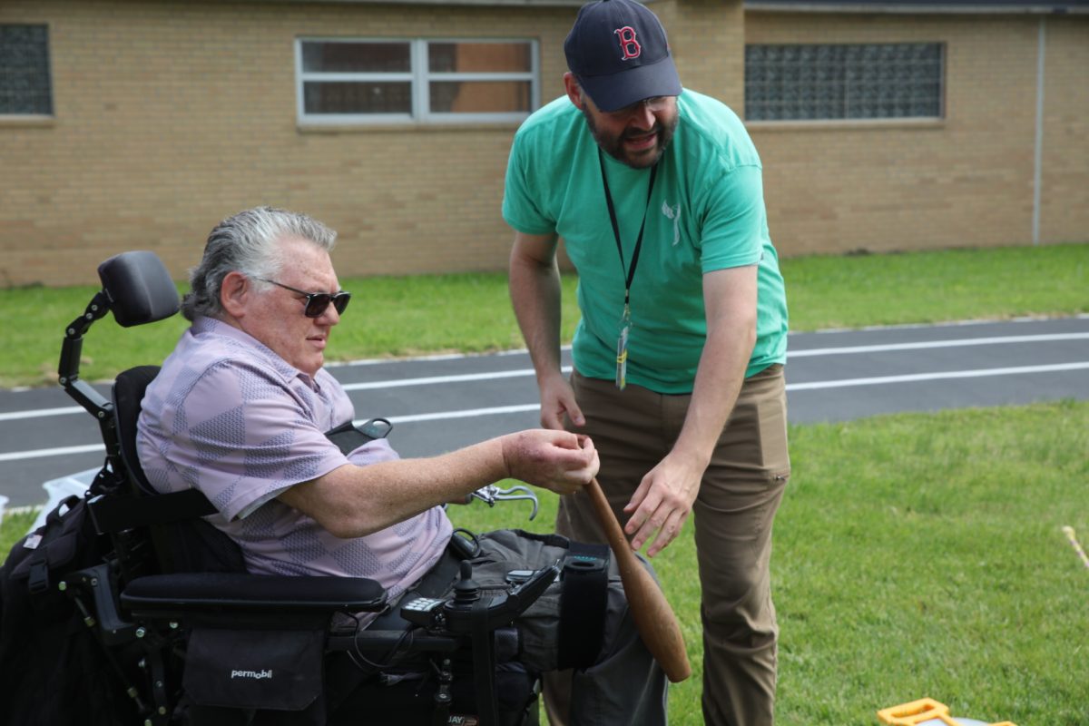 Along with lunch, the VFW Day of Service at the Spinal Cord Unit at Jefferson Barracks VA Medical Center featured a climbing wall, bowling, bocce, cornhole, relay races and track and field events. Pictured above, Lars Lifrak, a physical therapist assistant in the Spinal Cord Injury Unit, assists Bobby Jackson with a point-free javelin. “This is what rec therapy does — figure out ways to have things be adapted,” Lifrak said.