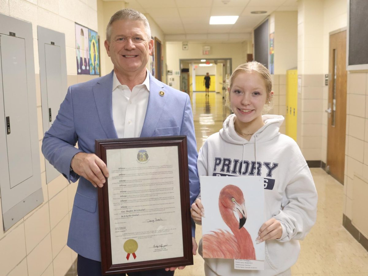 Mcrae Leick holds her painting “Pink Dreamers” while posing for a photo with Senator Doug Beck. Photo courtesy of the Mehlville School District. 