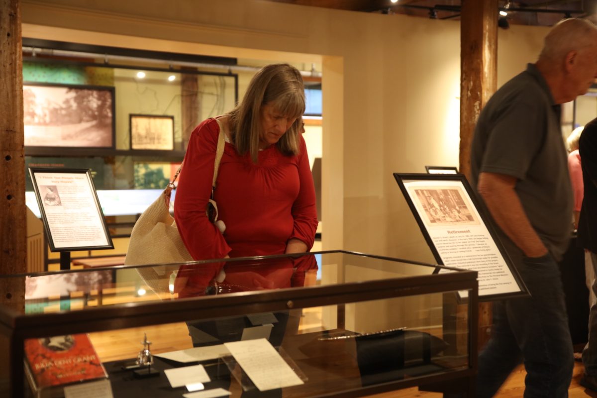 At the Julia Dent Grant exhibit's grand opening, an attendee looks at a plate given by Grant to her son.