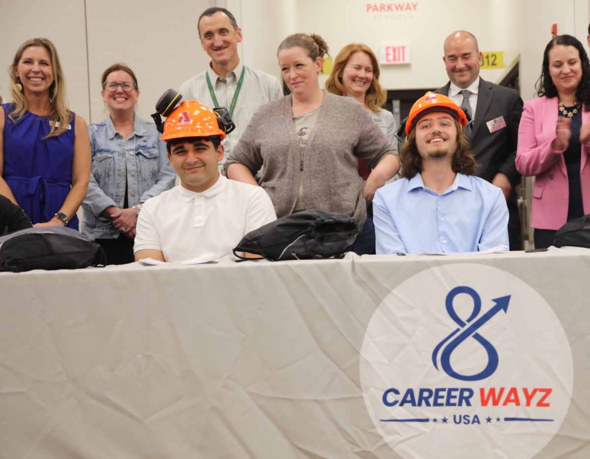 Lindbergh High School’s Sadeq Alyasseri (left) and Mehlville High School’s Deagan Giannas (right) pose in their Jost Chemical orange hard hats after signing with the aforementioned company on May 26 at the first-ever St. Louis Registered Youth Apprenticeship Signing Day. As seen above, after signing with a company, apprentices were given merchandise such as hats and shirts to advertise and represent their new employer.
