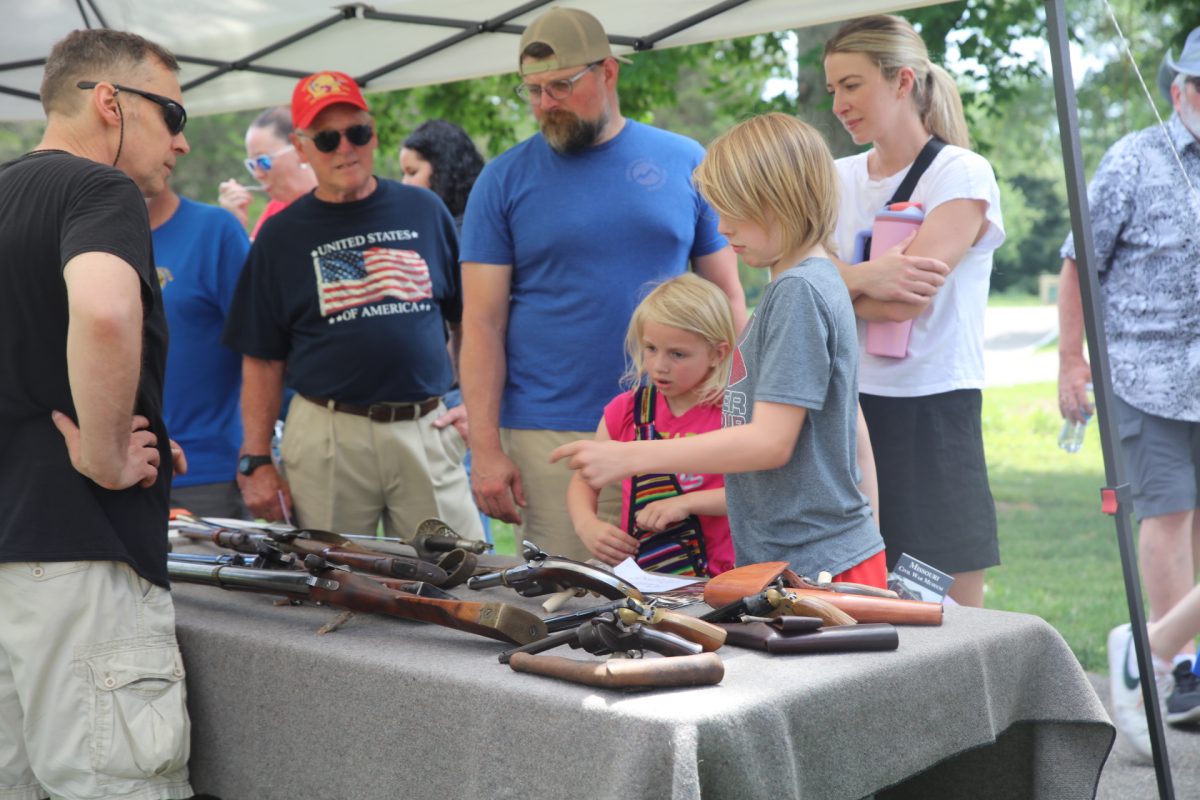 A family looks at vintage firearms at the Missouri Civil War Museum's table.