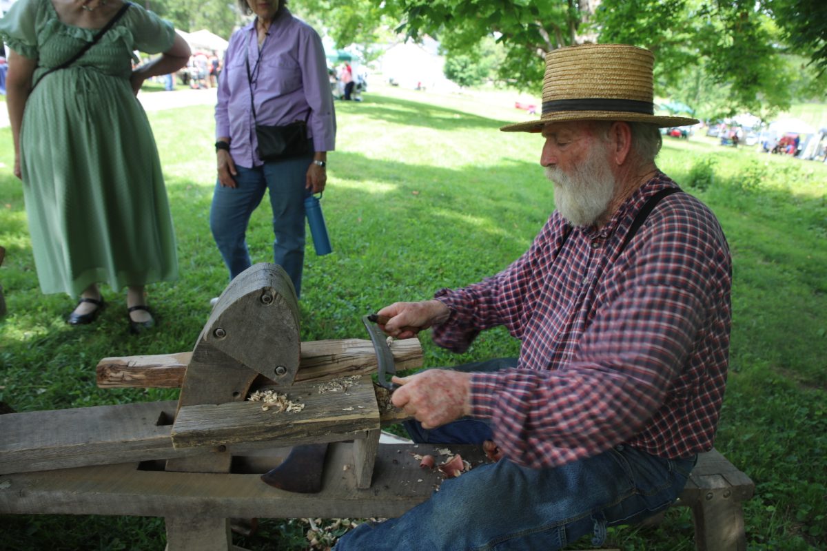 Emmons uses a draw knife to shave down various cuts of wood.