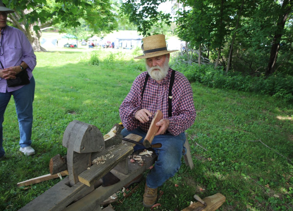 Tim Emmons, a Faust Park museum educator, explains to passersby how to use a draw knife.