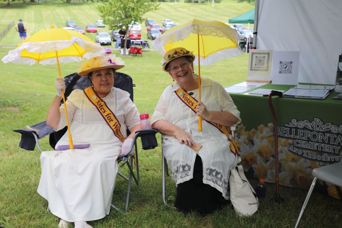 Sherri Morrow and Edna Dieterle pose dressed in outfits inspired by the women's suffrage movement. 