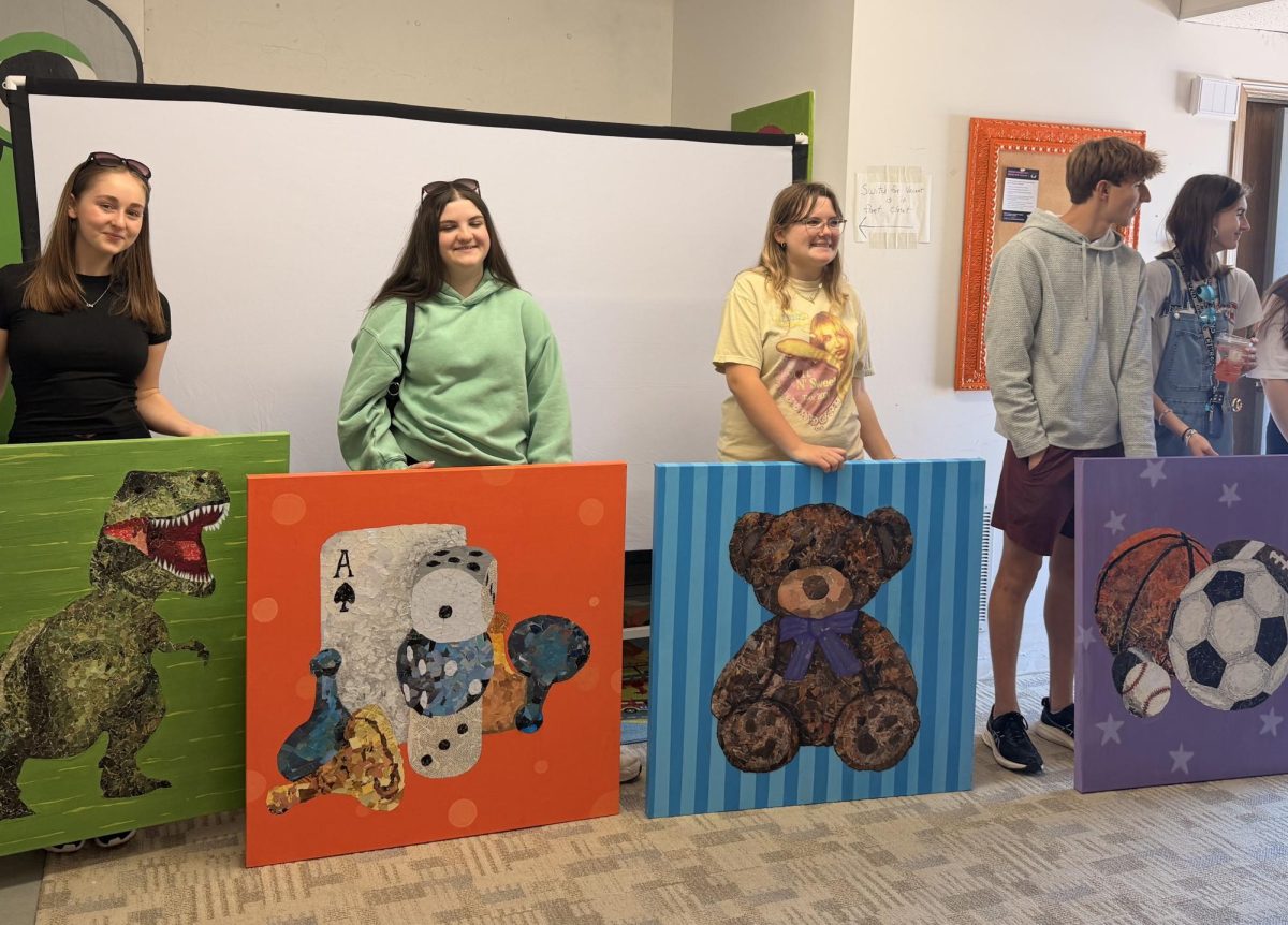 Lindbergh High School students stand with the four canvases that will be hung in the Angels' Arms warehouse. Photo courtesy of Jessica Fisk.
