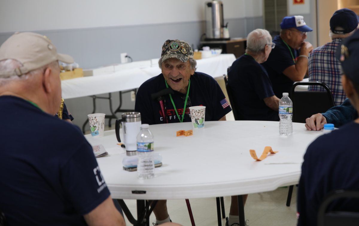 A veteran wearing a United States Army hat listens closely to what his peer is saying at the July 28 coffee talk.