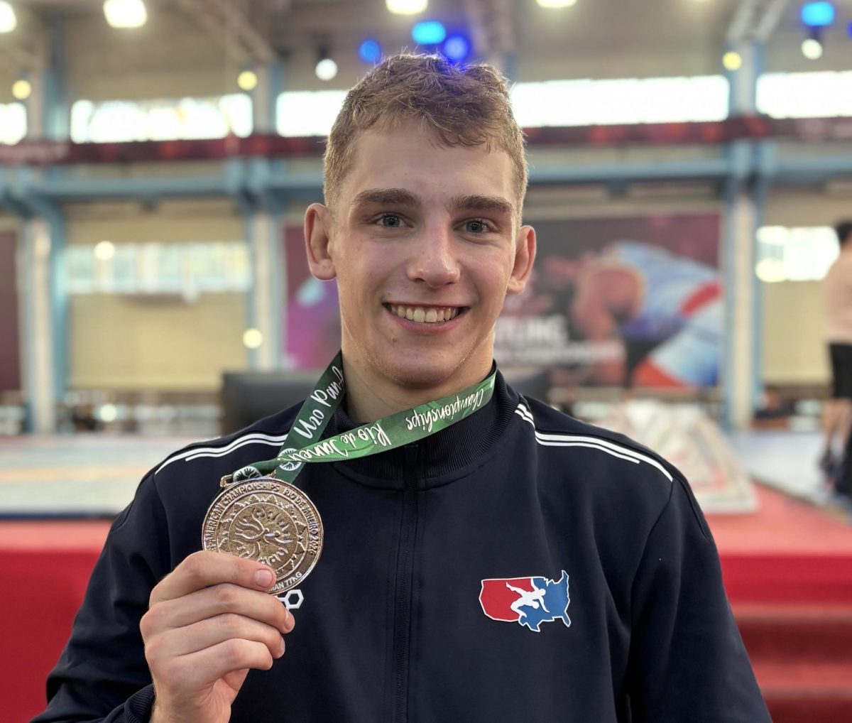 Will Scherer holds up his silver medal from the 2026 U20 Pan-American Championships. 