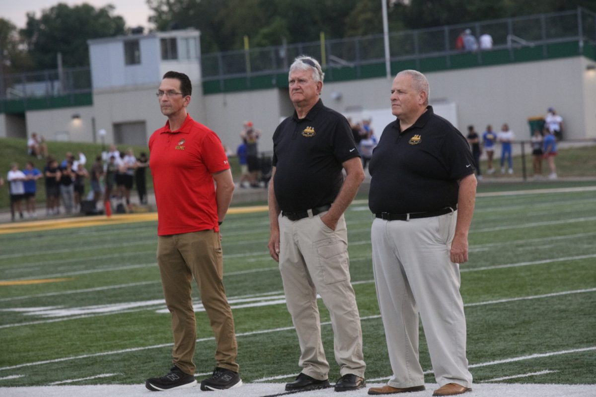Eureka Fire Protection District Chief Greg Brown and retired Eureka Police Chief Mike Wiegand — who, together, represent 92 years of service to the Eureka community — were honored on the field before the game. Standing alongside the two is Colin Davitt, a Marine veteran, and the Director of Artificial Intelligence and Blended Learning at Lindbergh Schools.