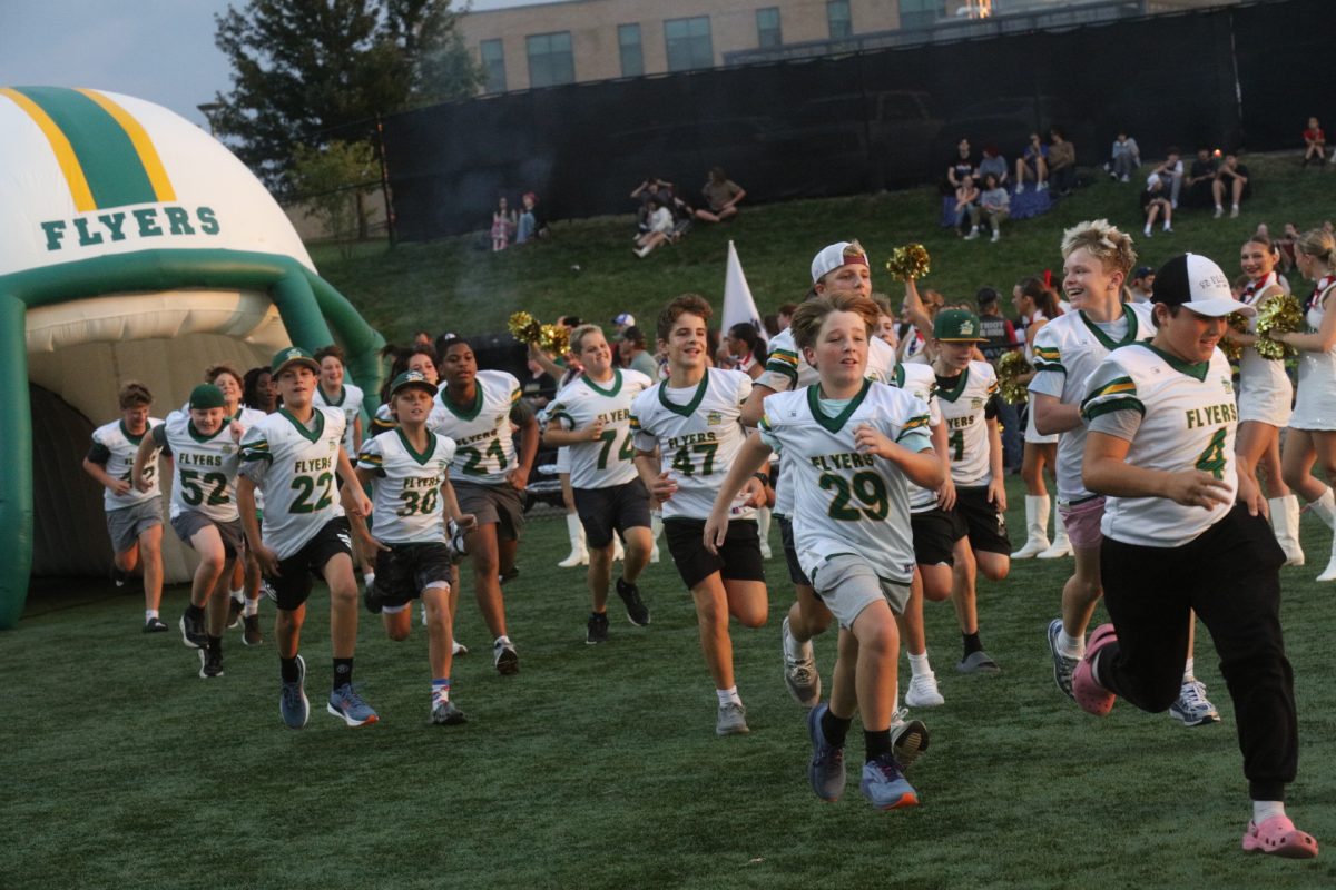 Young Flyers run towards the field on Sept. 11, setting the stage for the varsity football squad.