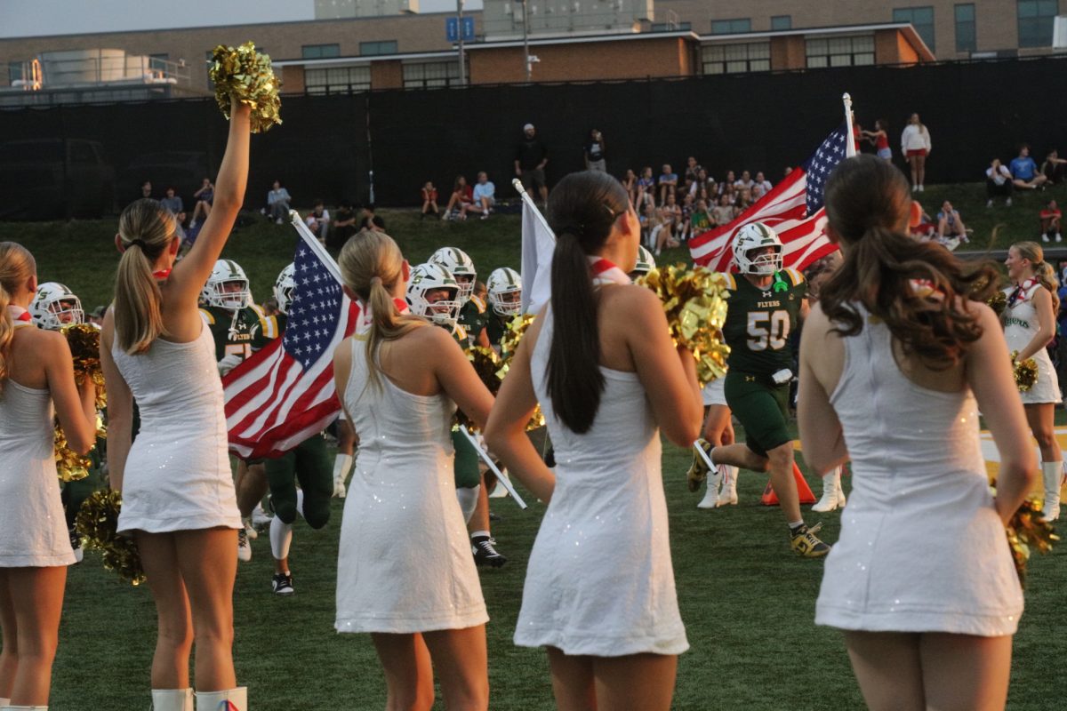 Following a motor escort from the Missouri Patriot Guard Riders, the Lindbergh High School football team rushes towards Flyers Field.