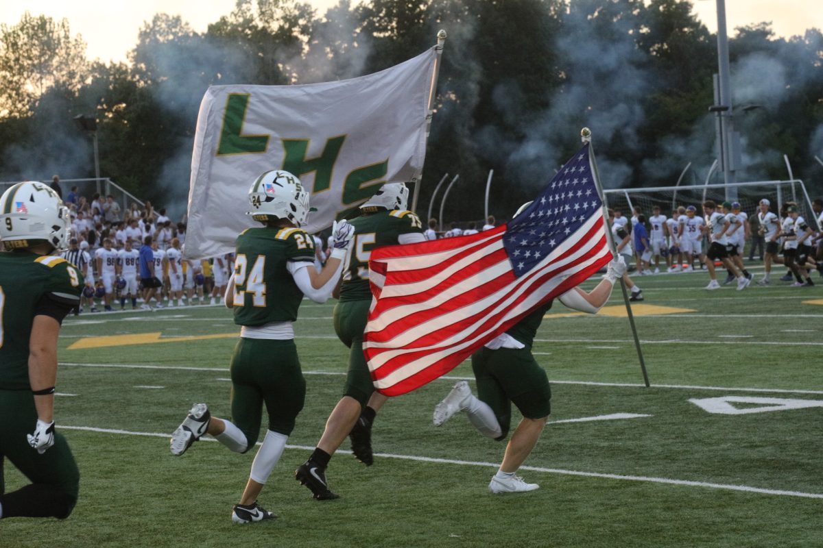 Holding an American flag and a Lindbergh High School flag, members of the Flyers' football team make a grand entrance to their game on Sept. 11.