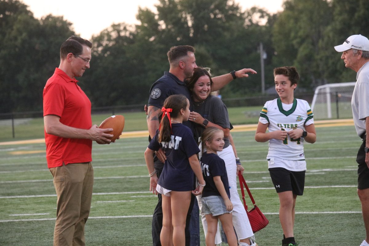 St. Louis Metropolitan Police Department SWAT Officer Matt Gregston is greeted by his family after delivering the game ball to Colin Davitt, the evening’s Honorary Captain.