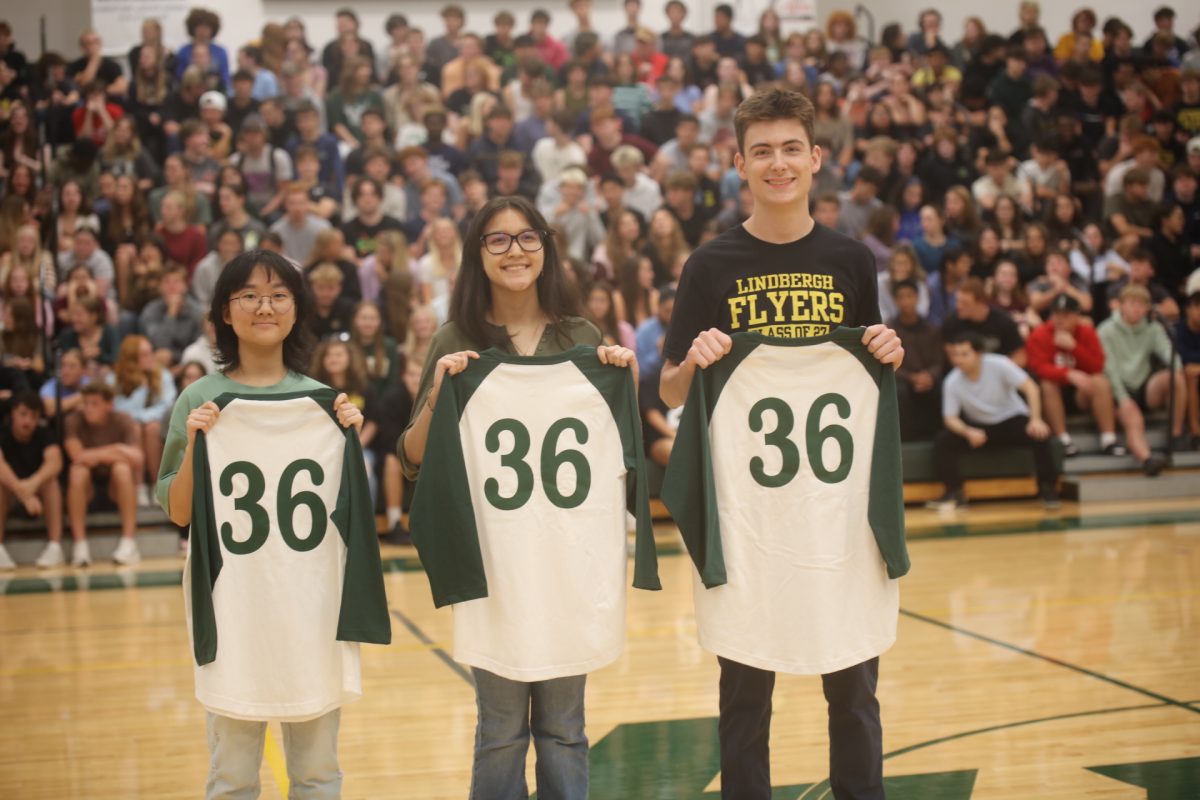 The three Lindbergh High School students with perfect ACT scores pose at the assembly with their jerseys. 