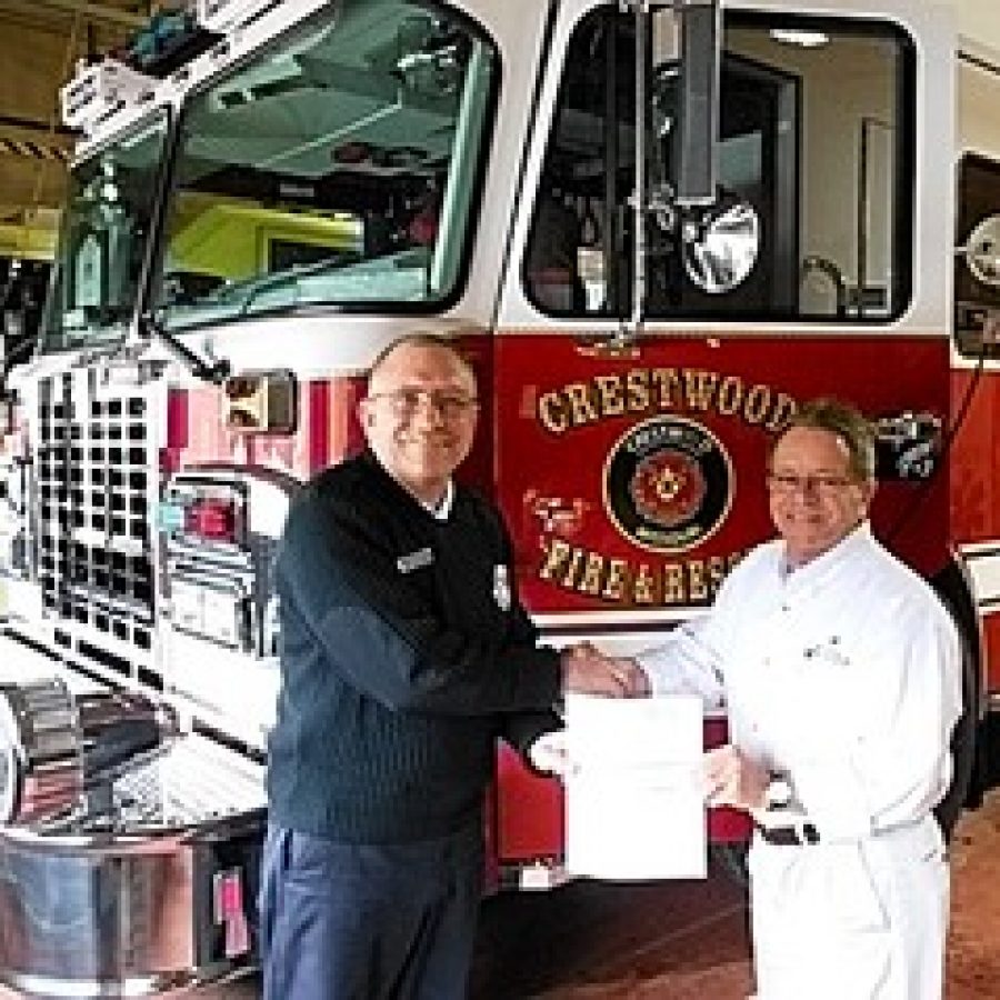 Crestwood Fire Chief Mark Menning, left, accepts a check for \$1,200 from Bradley Brown, Missouri American Water manager of government affairs. 