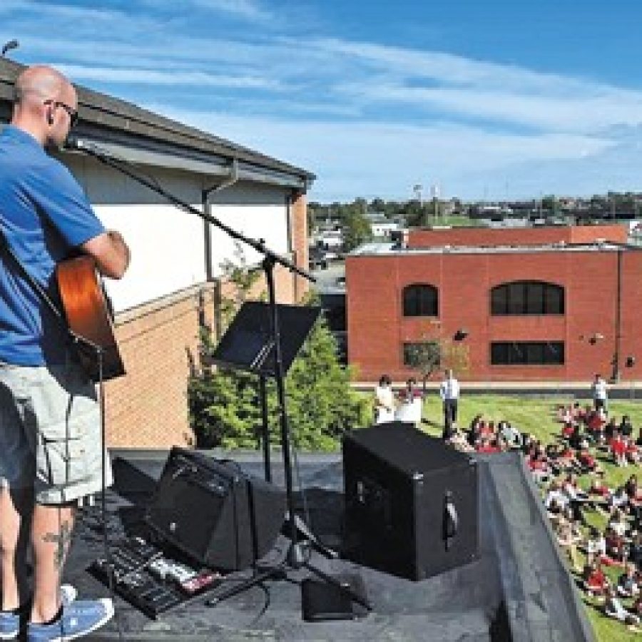 Shawn Hecksel, director of the Youth and Children's Ministry at Abiding Savior Lutheran Church and School on Butler Hill Road, leads an outdoor rooftop celebration, 'Shout from the Rooftop,' in recognition of the school's 30th anniversary.