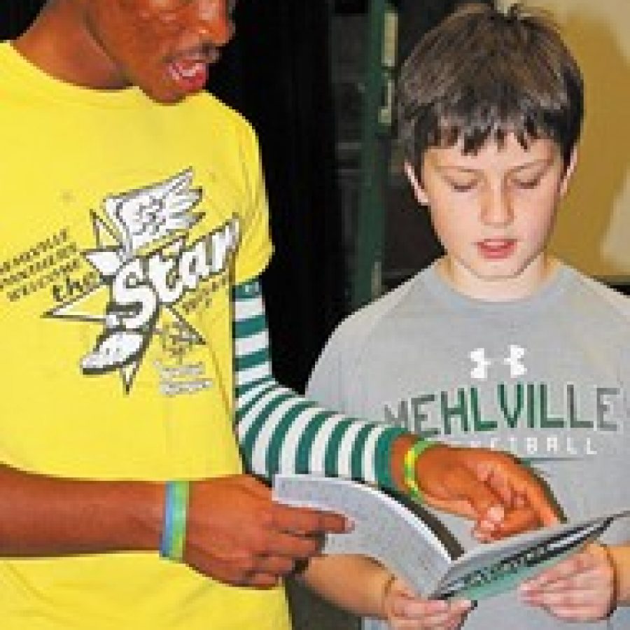 MHS Show Choir student Davonne Canady, a senior, and Joe Powers, a fifth-grade camper from Hagemann Elementary, prepare to run through a number at last Fridays Show Choir Camp. 