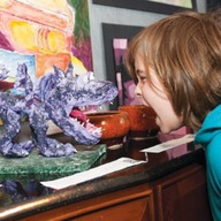 James Wollaeger takes on The Screamer, a three-dimensional dragon created for last years Young at Art Show by Christ Community Lutheran School student Abby Mitchell. 