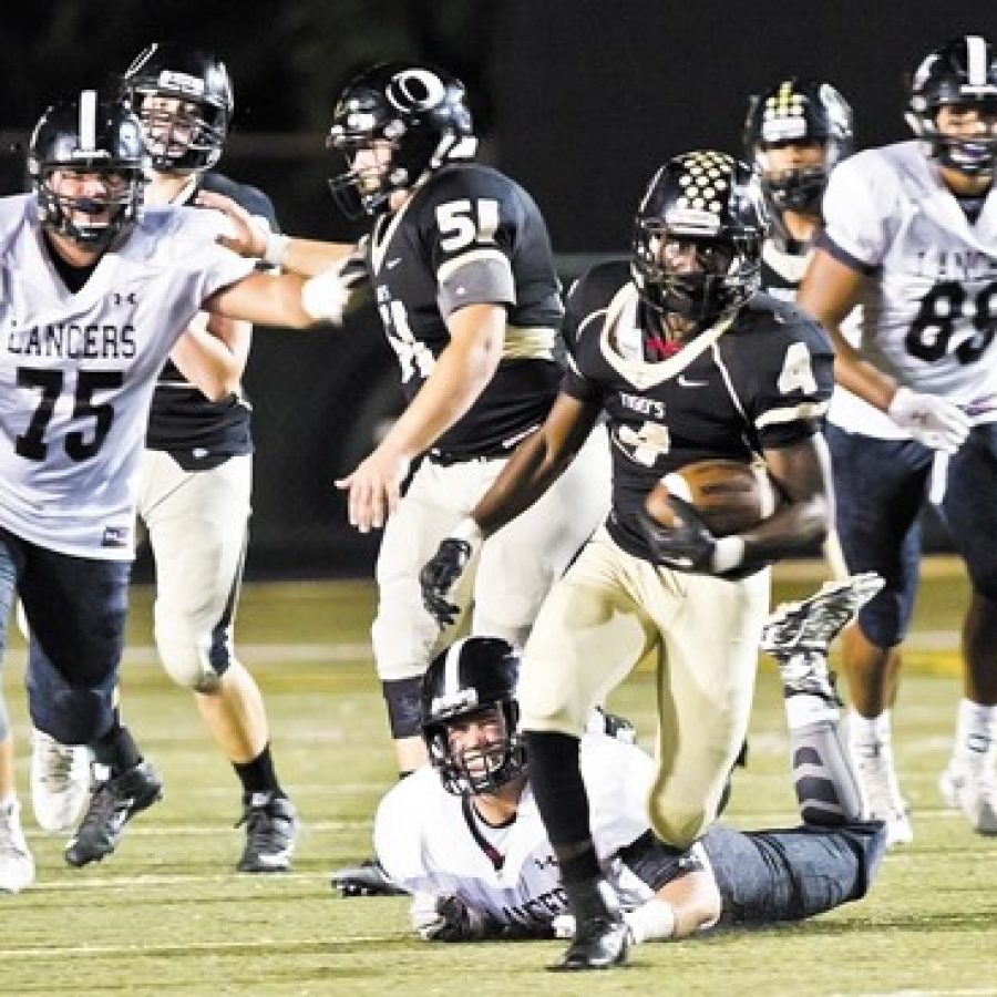 The Oakville Senior High School football team fell 44-27 to the Lafayette Lancers Friday night in Oakvilles Homecoming game. Above, Oakville Highs Norvell Streeter, No. 4, is pursued by Lafayettes Chase Behrndt, No. 75, and Michael Farinella, No. 88.