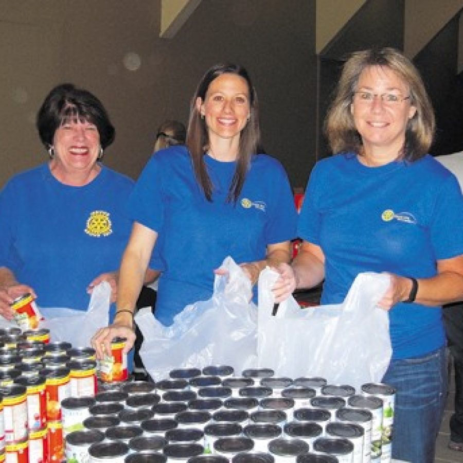 Rotary Club members, from left, Diana Lineberger, Chris Cipolla and Debby Schiavo pack food bags to be distributed to Lindbergh and Mehlville students.