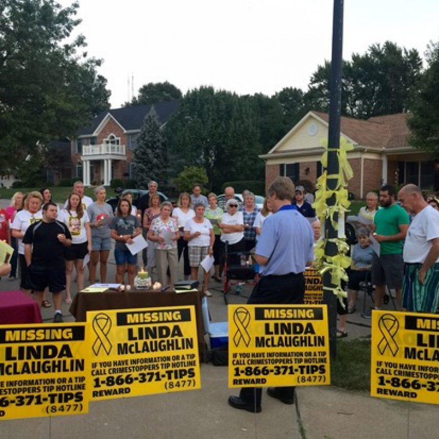 Linda McLaughlins pastor, Joel Christianson, center in blue, leads attendees at a candlelight vigil Tuesday night in a prayer for her safe return.