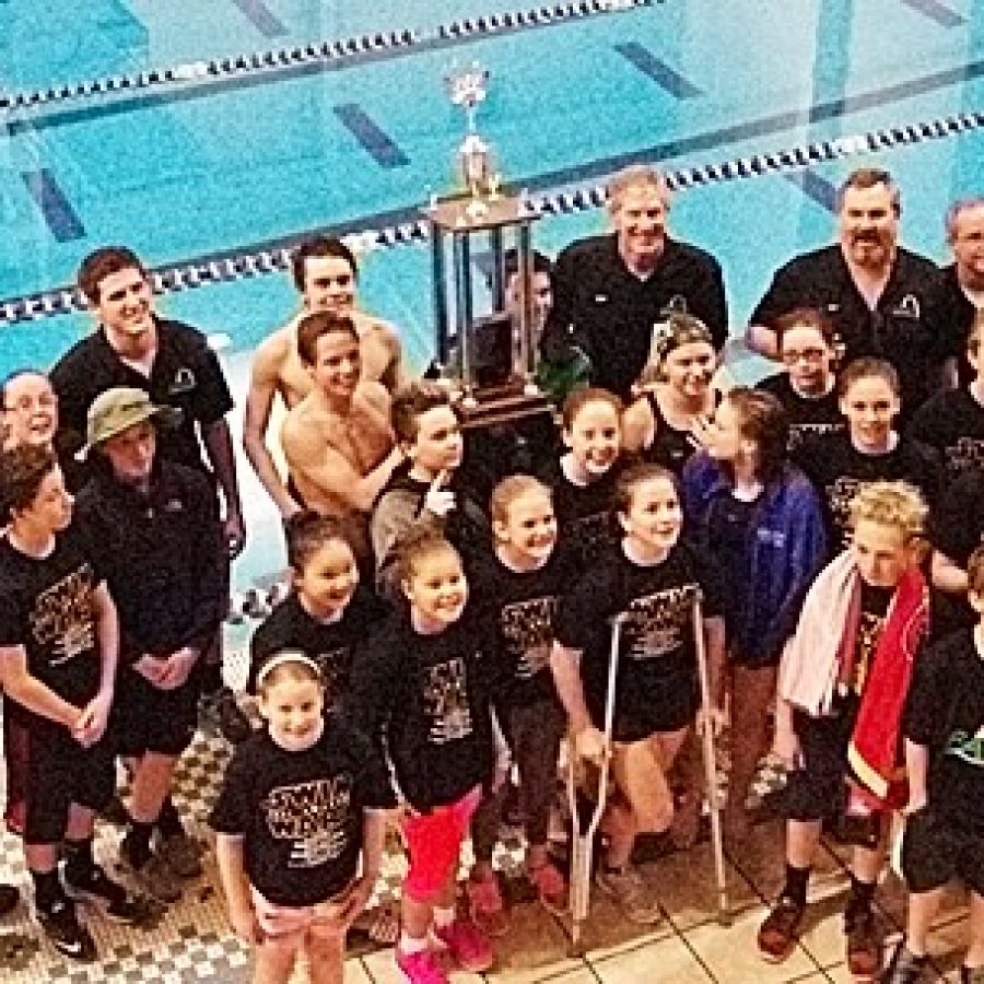 Members of Flyers Aquatic Swim Team are pictured with their trophy for winning the Ozark Swimming Division 1 Swim Meet championship for the second consecutive year.