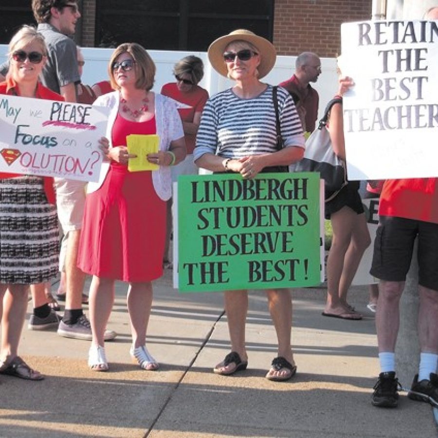 Lindbergh Schools teachers, including Lindbergh National Education Association Vice President Gretchen Moser, second from left, join alumni and residents in front of the Lindbergh High School auditorium before the June 14 Board of Edu-cation meeting to express their dissatisfaction with teacher pay. Teachers and their supporters also lined South Lindbergh Boulevard with signs before the school board meeting, which was attended by roughly 400 people.