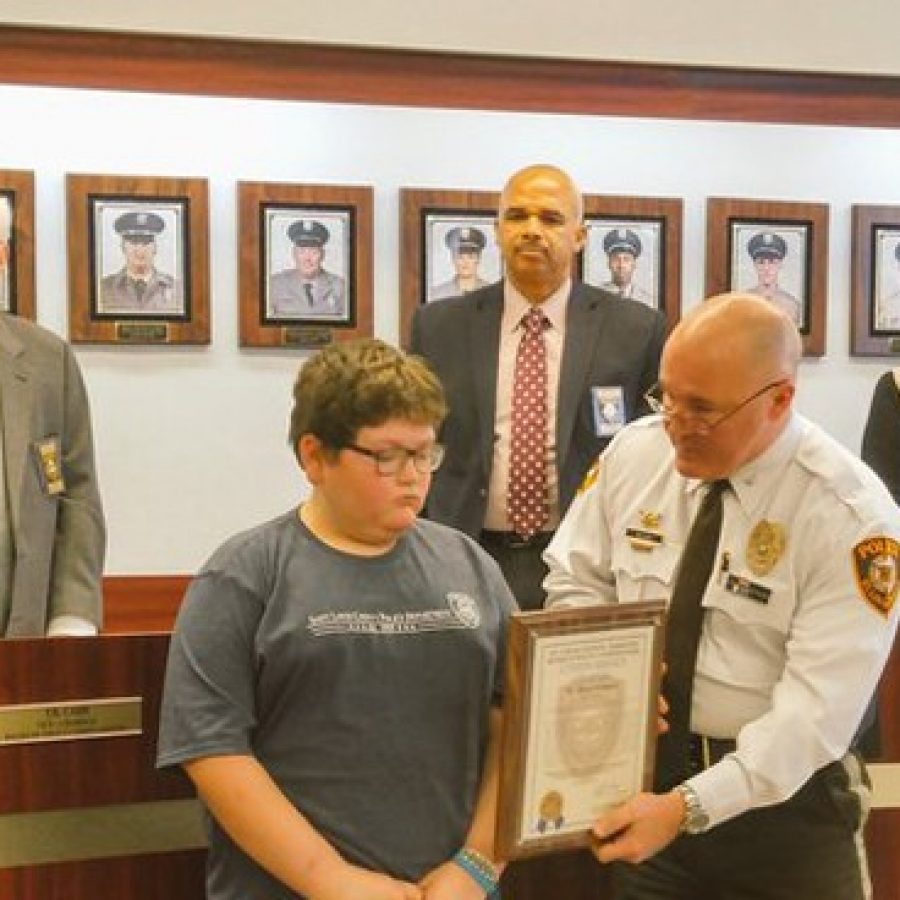 Above, Chief Jon Belmar presents a Citizens Citation to Sperreng Middle School sixth-grader Blake Hohman, 12, at the January county Board of Police Commissioners meeting. Pictured in the back is the police board, from left, T.R. Carr, Chairman Roland Corvington and Laurie Westfall.