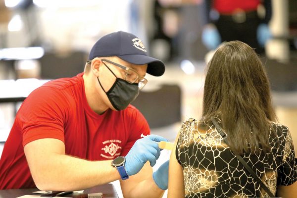 A Mehlville Fire Protection District employee administers a Johnson & Johnson vaccine dose at a vaccine clinic at Bernard Middle School Saturday, April 3. 