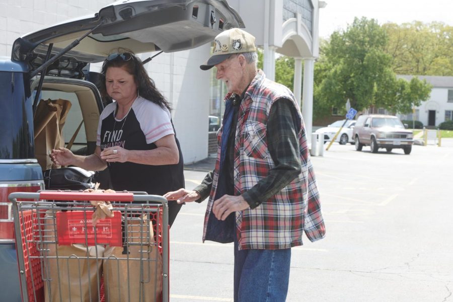 Caregiver Denise Phelps helps her 85-year-old uncle, William Speck, with groceries obtained from Feed My People in Lemay, Mo., on April 24, 2020. 