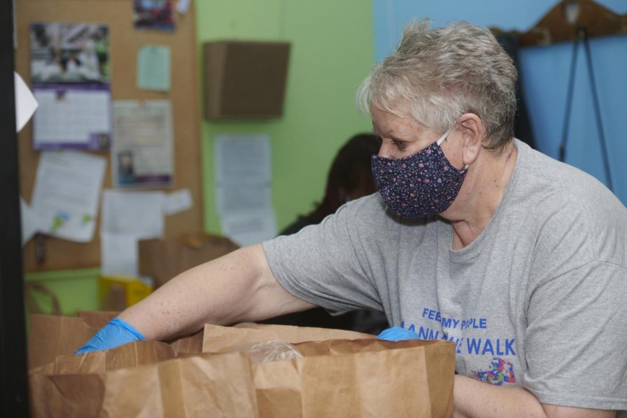 Feed My People volunteer Denise Huber follows COVID-19 safety precautions as she prepares and delivers grocery and personal care items provided by the nonprofit Feed My People at its facility in Lemay, Mo. It also operates a food pantry in High Ridge, Mo.