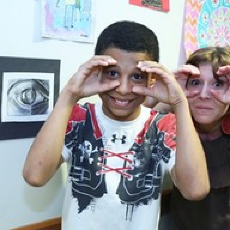 Myles Kee, 11, and art teacher Kris Wollaeger of Kirkwood, mimic Myles' art piece at the fifth annual Fountain View Young at Art Show at Friendship Village Sunset Hills. Myles is the son of Lisa Kee of Shrewsbury.
 