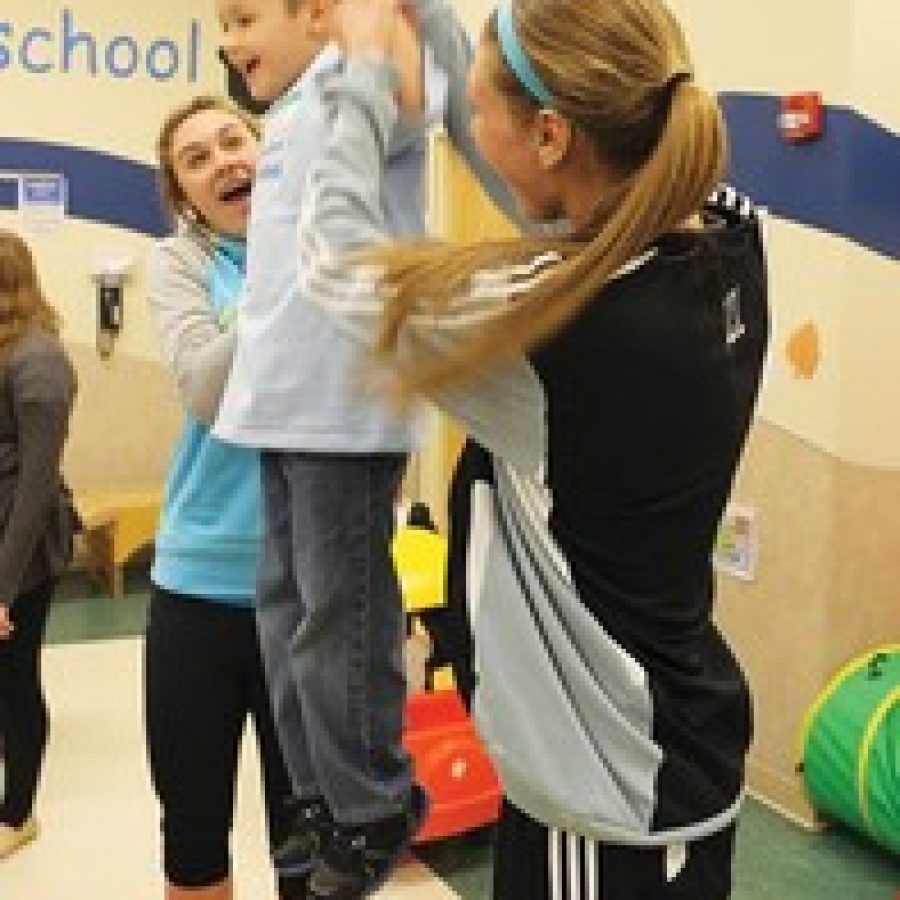 Mehlville Senior High School students who are serving as members of the high schools Special Olympics steering committee are pairing up with children who attend the John Cary Early Childhood Center to put on mini-Special Olympics events on Wednesdays. Pictured, from left, are Mehlville High junior Kayla Drew, early childhood center student Elijah Teal and Mehlville High junior Mackenzi Giorgi.
 