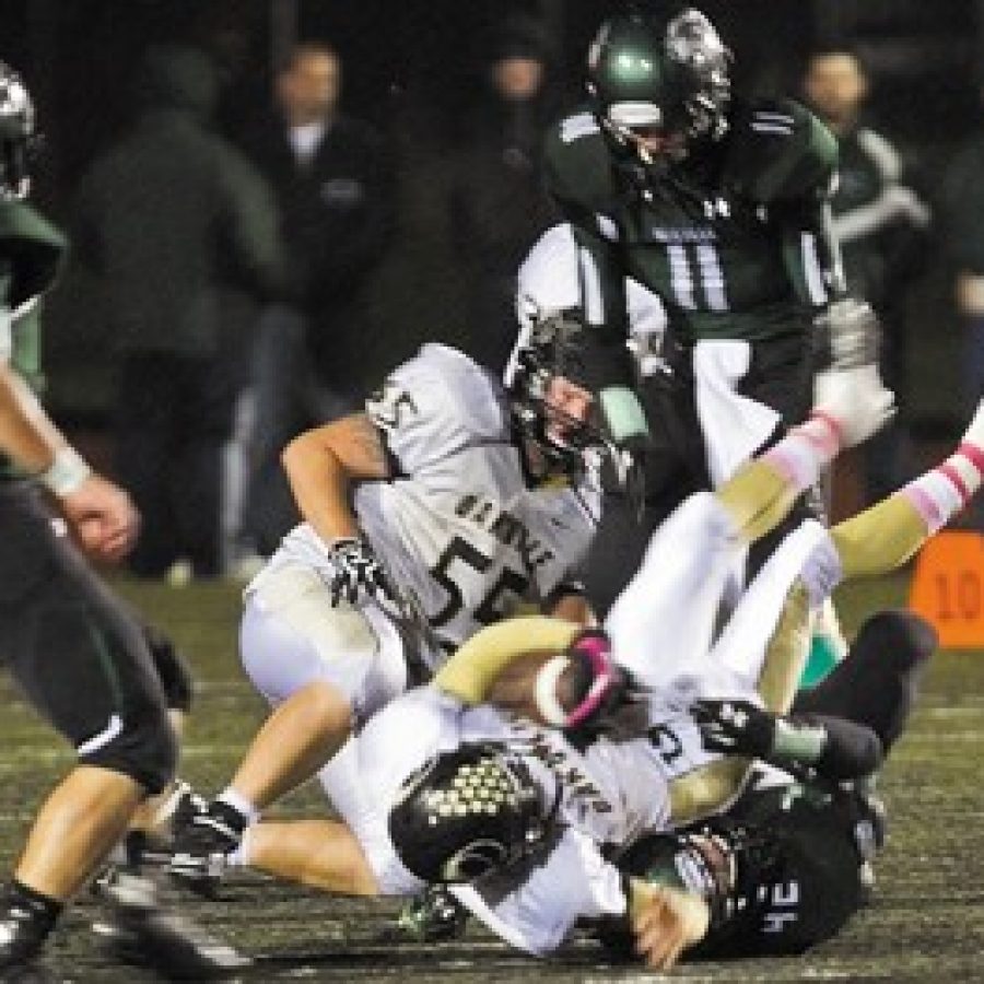 Oakville quarterback Carvon Robinson, with ball, is tackled in Friday nights game by Mehlvilles Kyle Kaletka, No. 42.